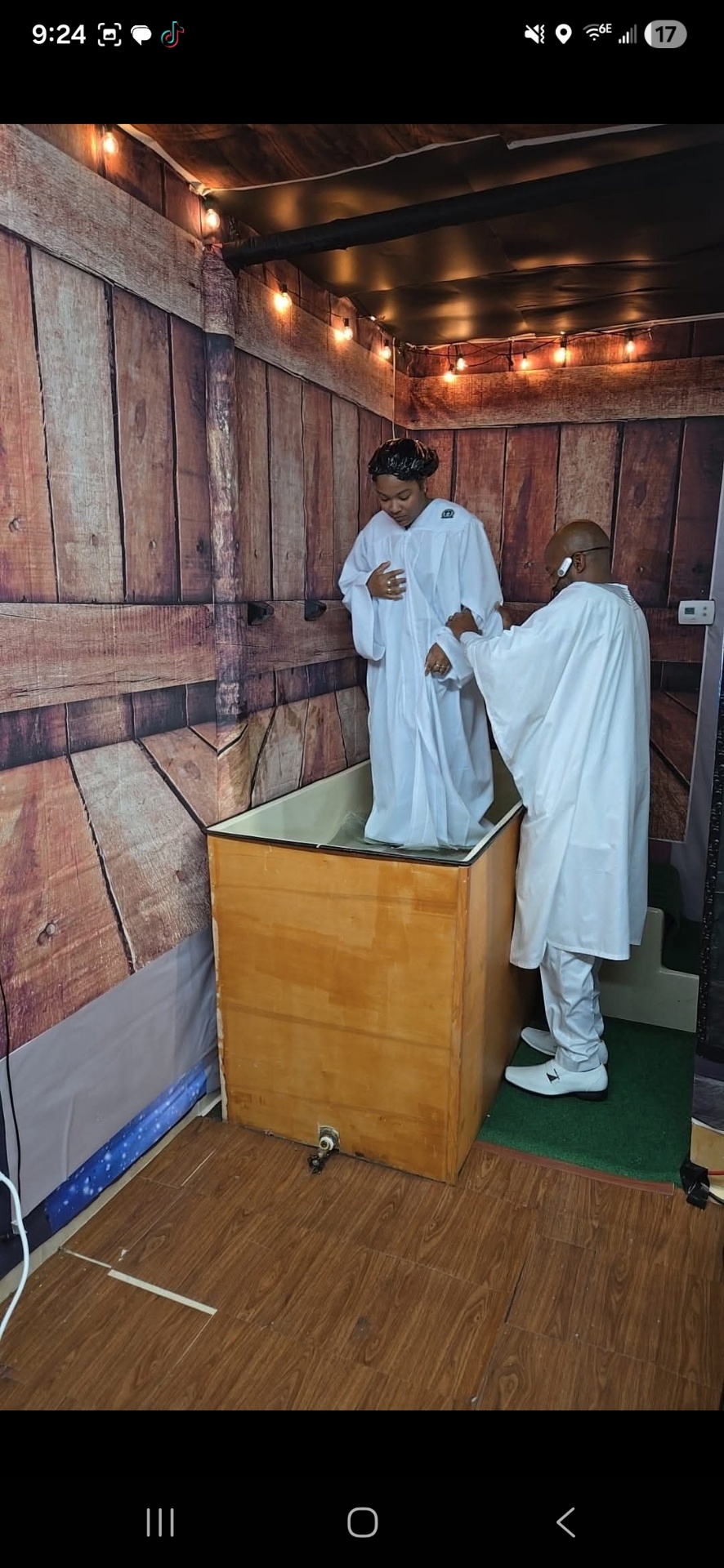 Baptism candidate prepared in white robe before immersion