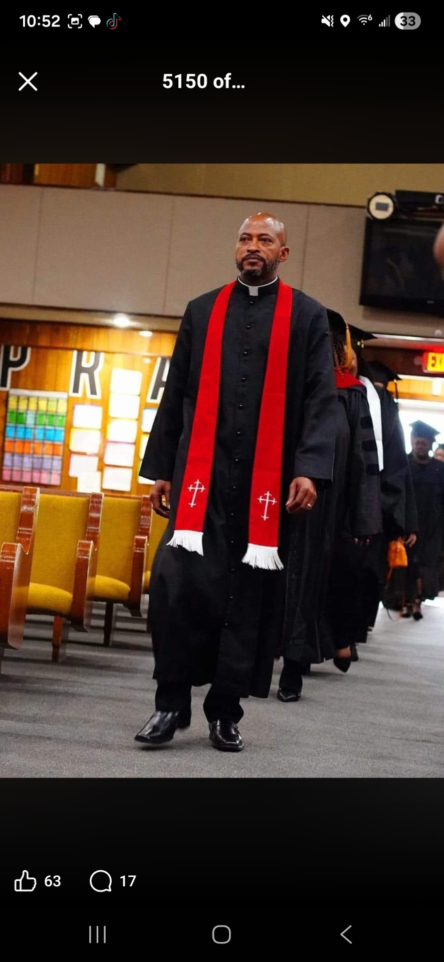 CALA graduation processional — pastor in clergy robe with red stole